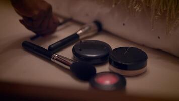 une intervalle de maquillage articles et une sélection de brosses sont soigneusement arrangé sur une pansement table video