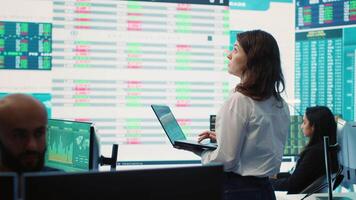 Member of the advisory board examines potential business expansion, supervisor look into data visualizations on a big screen in the office. Seeks to boost affordable earnings. Camera A. video