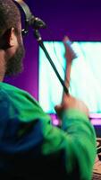 Vertical Confident music engineer working on mixing console in home studio, producing new sounds for a song and editing volume levels in daw software. Audio technician recording acoustic files. Camera A. video