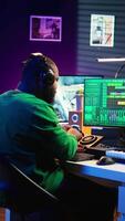 Vertical Confident music composer mixing sounds on digital audio software, creating a cool atmosphere in his home studio. Young cheerful producer composing new soundtracks with stereo gear. Camera B. video