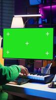 Vertical Producer composing music with electronic keyboard notes and green screen display on pc, post production in home studio. Musician artist plays midi controller next to mockup layout. Camera B. video