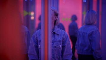 A woman is seen reflecting in a mirror with striking lighting, creating a bold aesthetic atmosphere video