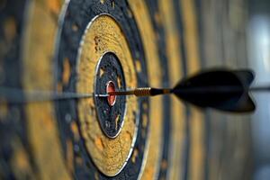 Dart hitting the center of an old target on blurred background photo