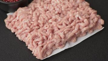 Raw minced chicken with salt, spices and herbs on a dark concrete background video