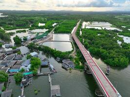 Aerial landscape of Pak Nam Prasae estuary in Rayong, Thailand. Fishing community, mangrove forest, and river showcase sustainable ecotourism and net-zero travel in a biodiverse coastal ecosystem. photo