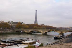 Autumn View of Eiffel Tower and Seine River with Boats and Bridge in Paris photo
