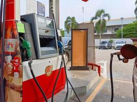 Jakarta, Indonesia, 2024 - A car refueling at a gas station in Jakarta. A Pertamina fuel filling machine with various types of fuel. photo
