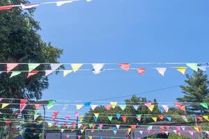 The colorful flags between the trees at a celebration event photo