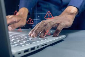 Man working on laptop with red triangle caution warning sign on virtual screen for notification error, restricted content or maintenance concept photo