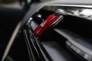 Red hazard button or emergency warning light button on the car dashboard photo
