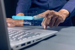 Man using laptop to update software. Updating process bar on virtual screen. photo