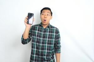attractive asian man show smartphone screen with surprised face expression isolated on white background photo