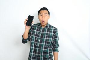 attractive asian man show smartphone screen with surprised face expression isolated on white background photo