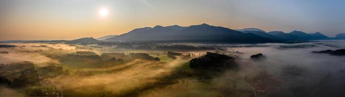 Sunset Panorama with drone at the Bavarian Alps. Mist and fog at the ground photo