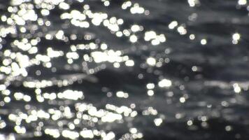 Bokeh sun glare reflected from the water surface in sunny summer day, abstract blurry background from water. Sun glare on the water. video