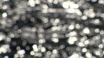 Bokeh sun glare reflected from the water surface in sunny summer day, abstract blurry background from water. Sun glare on the water. video