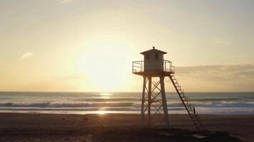 Lifeguard Tower on an Empty Beach at Sunrise with Golden Light and Gentle Waves video
