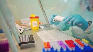 Research worker with medical instruments. Laboratory assistant drops some liquid into small vial on a table in clinic. video