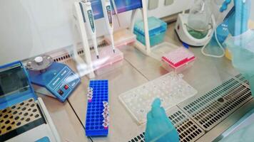 Hands in sterile gloves working with test tubes. Medical worker fills vials with liquid on the table in the laboratory. video