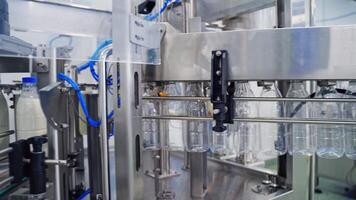 Bottles for milk on automatic production line. Dairy production in robotic factory. Empty bottles are filling with milk on manufacturing line. video