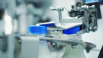 Automated machine covering plastic bottle with lid. Dairy production. Mechanical process of putting cover on a bottle with milk in a modern factory. video
