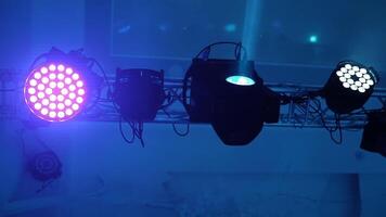 Lighting equipment flashing over the stage. Close-up spotlights with laser rays inside the disco club. Colorful lights in the modern hall glowing from the ceiling. video