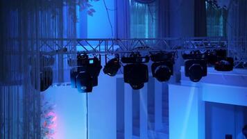 Blue background with colorful spotlights in the night club. Flashing rays with different colors glowing from projectors. Close-up. video