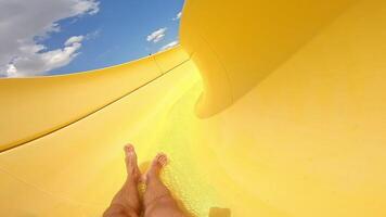 Fun down the water slide in summer day. Man goes down from water slide to swimming pool in aqua park. Quick way inside the pipe. video