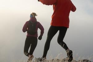 trail running couple man and woman running on a mountain path photo