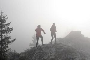 trail running couple man and woman running on a mountain path photo