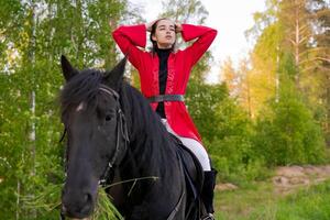 Woman is riding a horse in a forest photo