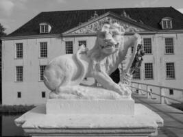 A statue of a lion in front of a large building photo