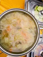 photo of vegetable soup in a pot on the table ready to be served to guests