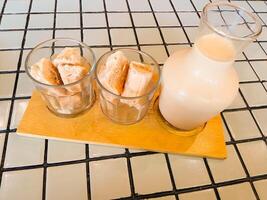 photo of iced milk tea on a wooden table with a square marble pattern