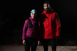 trail runners couple portrait while preparing for an early morning run in the night time with a headlamp photo