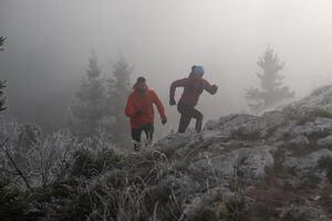 trail running couple man and woman running on a mountain path photo