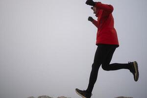 sky running or trail running woman exercising on a mountain top photo