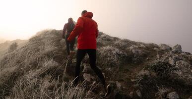 trail running couple man and woman running on a mountain path photo