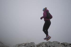 sky running or trail running woman exercising on a mountain top photo