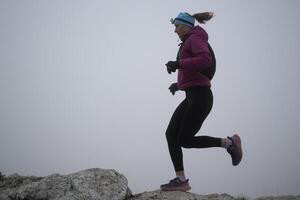 sky running or trail running woman exercising on a mountain top photo