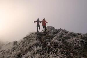 trail running couple man and woman running on a mountain path photo