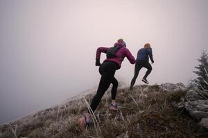 trail running couple man and woman running on a mountain path photo