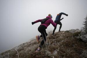 trail running couple man and woman running on a mountain path photo