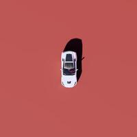 An overhead view of a white car on a red background photo