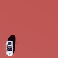 An overhead view of a white car on a red background photo