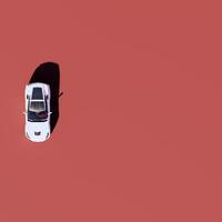 An overhead view of a white car on a red background photo
