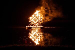 Geometric Structure Ablaze on Floating Platform at Night photo
