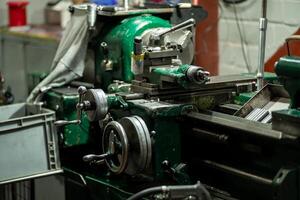 An old, well used lathe machine in a workshop, a vital tool for metalworking and precision engineering tasks. photo