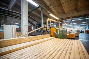 A large woodworking factory with stacks of freshly cut timber panels ready for processing, showcasing industrial efficiency and precision in a well lit manufacturing environment photo