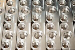 Metal components with precise threading, neatly arranged in rows, showcasing industrial precision and manufacturing quality. photo